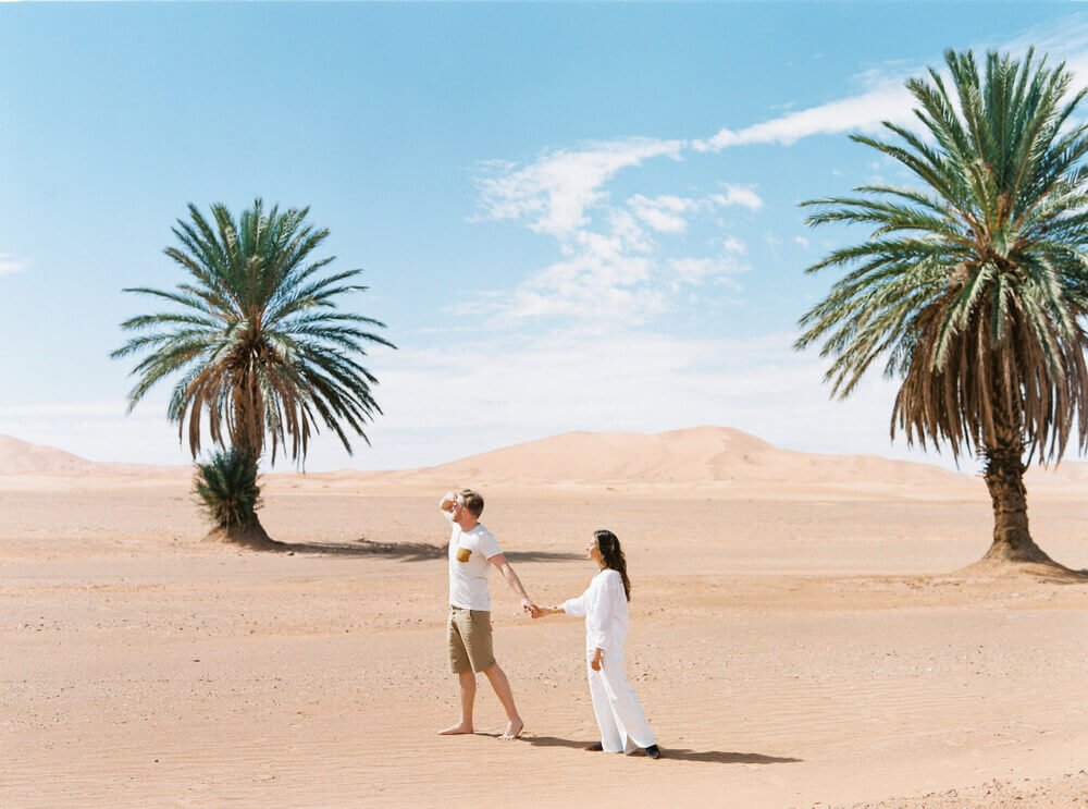 Romántica luna de miel en Marruecos, parejas disfrutando de un paseo en camello en el desierto de Merzouga durante el atardecer