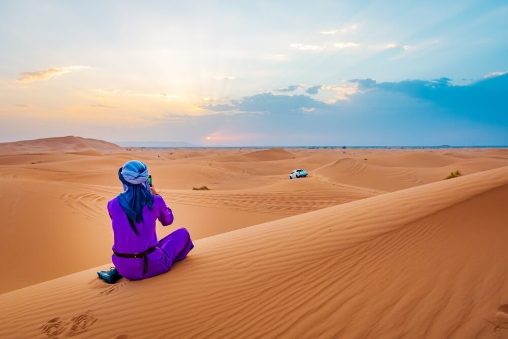 4x4 off-road vehicle navigating the dunes of Merzouga Desert, Morocco, during an adventure tour